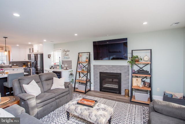 living room featuring light hardwood / wood-style floors, a fireplace, and wine cooler