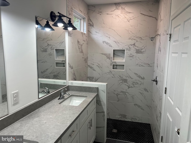 bathroom featuring tiled shower and vanity