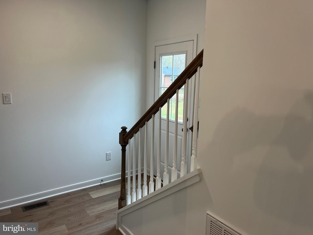 stairs with visible vents, baseboards, and wood finished floors