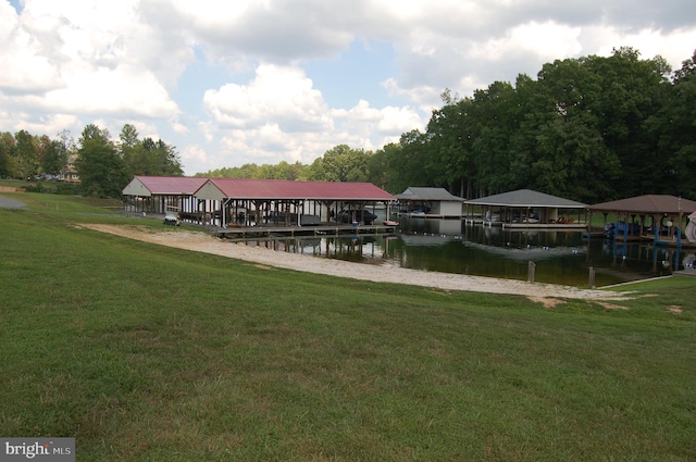 view of dock with a water view and a lawn