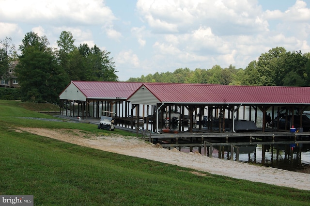 view of dock with a yard and a water view