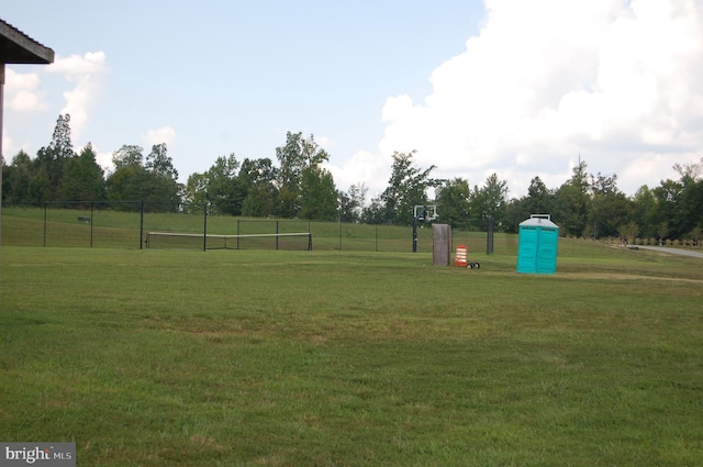 view of community featuring a yard and fence