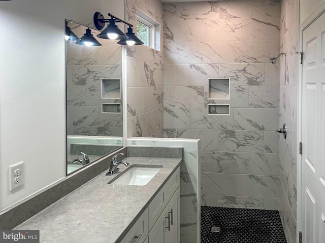 bathroom featuring tiled shower and vanity