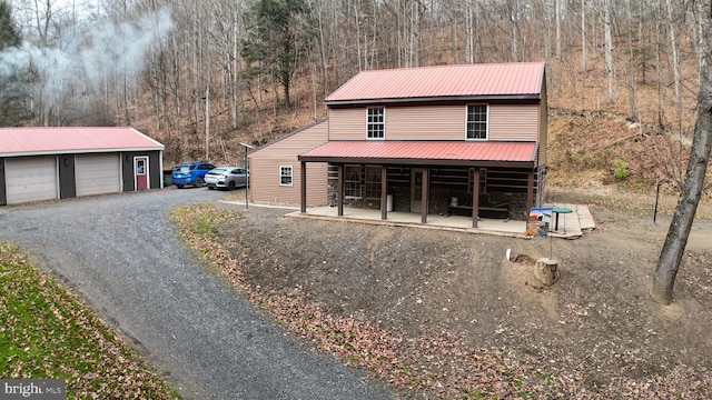 view of front facade featuring a garage, covered porch, and an outdoor structure