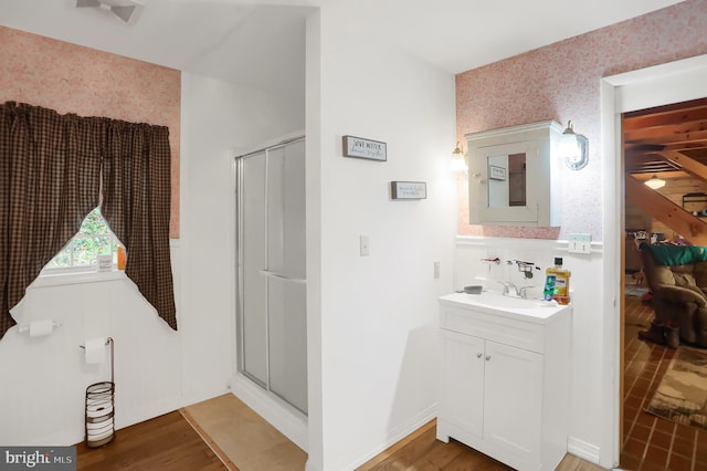 bathroom featuring hardwood / wood-style floors, vanity, and a shower with shower door