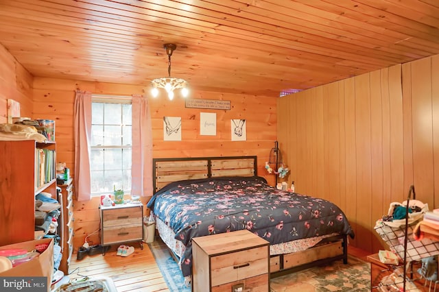 bedroom featuring a chandelier, wooden walls, light hardwood / wood-style flooring, and wood ceiling