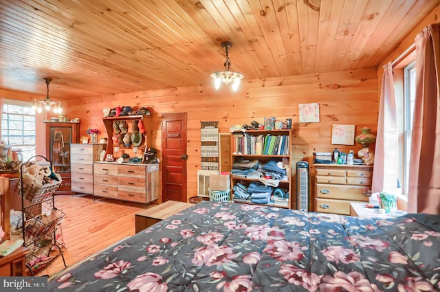 bedroom with wood walls, light hardwood / wood-style flooring, a chandelier, and wooden ceiling