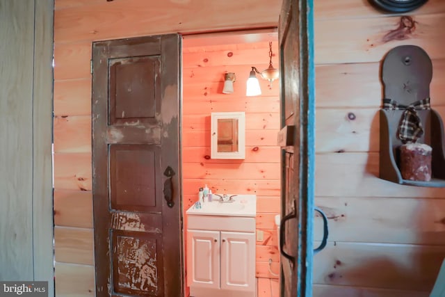 bathroom with wood walls and vanity