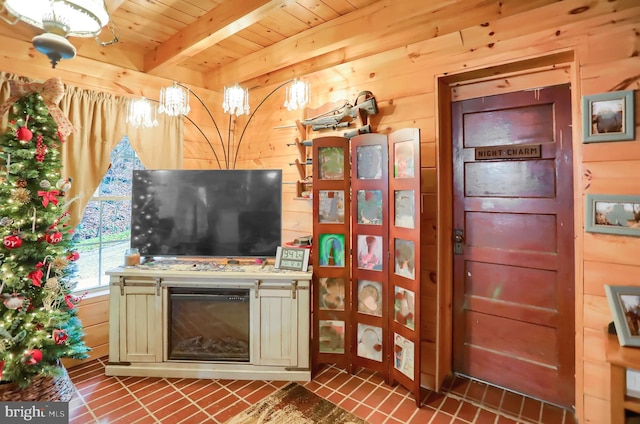 unfurnished living room featuring wood walls, beam ceiling, wood ceiling, and dark tile patterned flooring