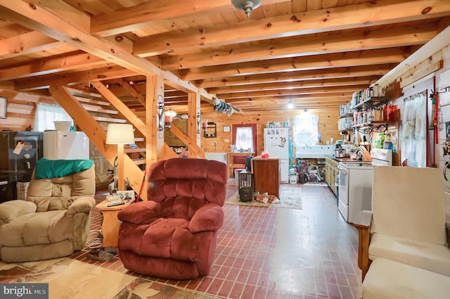 living room with beamed ceiling, wooden walls, wooden ceiling, and a healthy amount of sunlight