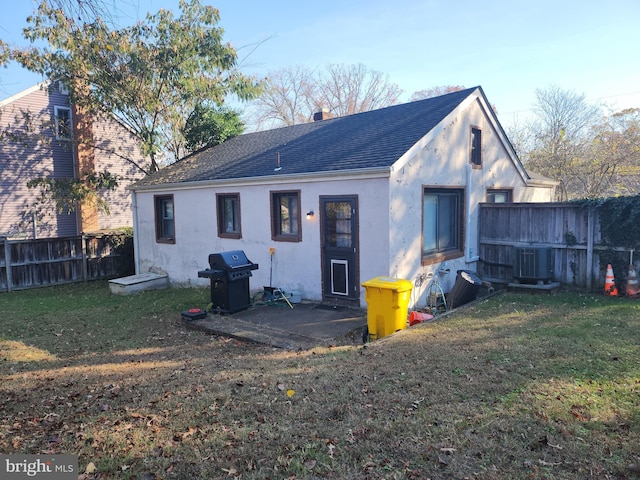 back of property with cooling unit, a yard, and a patio