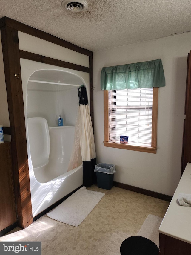 bathroom featuring vanity, a textured ceiling, and shower / bath combo