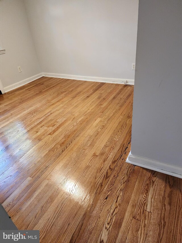 empty room featuring light wood-type flooring and baseboards