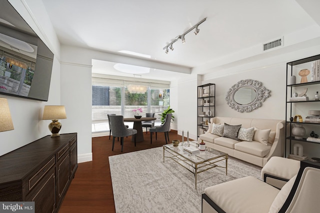 living room featuring track lighting and dark wood-type flooring