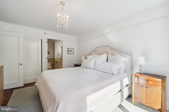 bedroom with dark hardwood / wood-style floors and ensuite bath