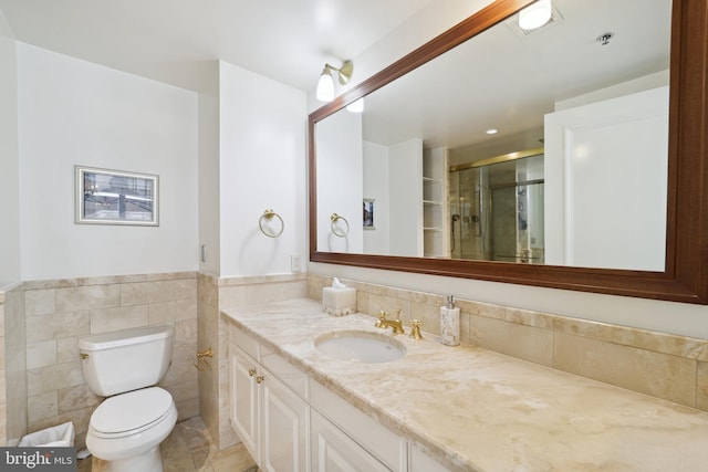 bathroom with toilet, vanity, tile walls, and walk in shower