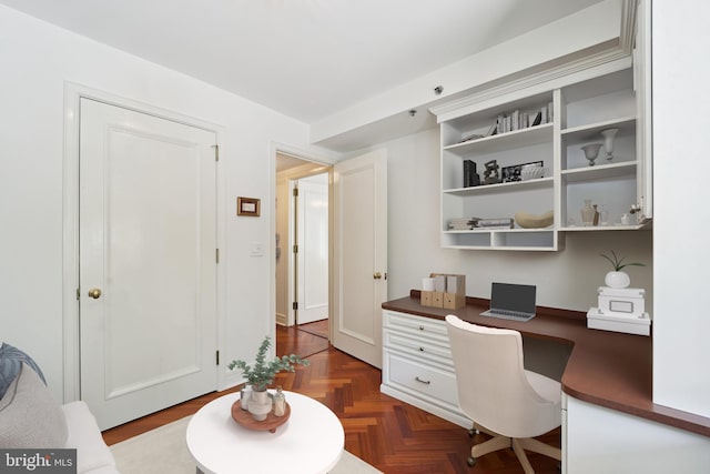 office featuring dark parquet flooring and built in desk