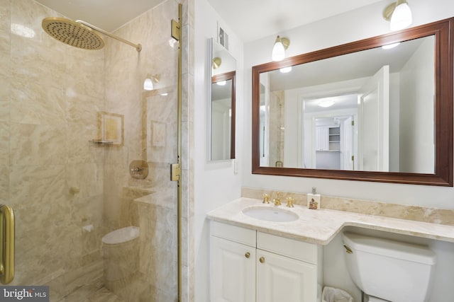 bathroom featuring vanity, toilet, and walk in shower