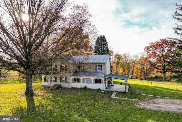 rear view of house with a carport and a lawn