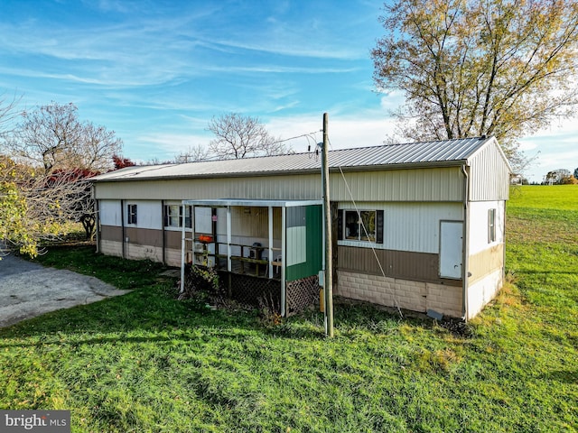 rear view of house featuring a yard