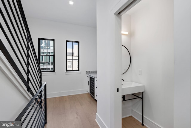 bathroom with beverage cooler and hardwood / wood-style flooring