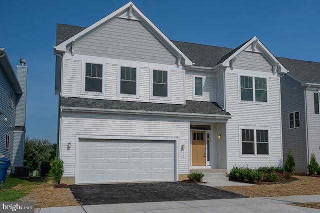 view of front of house featuring a garage and central air condition unit