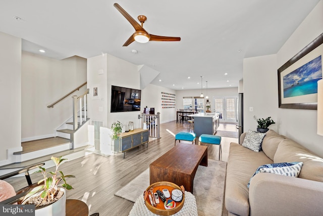 living room with ceiling fan and light wood-type flooring