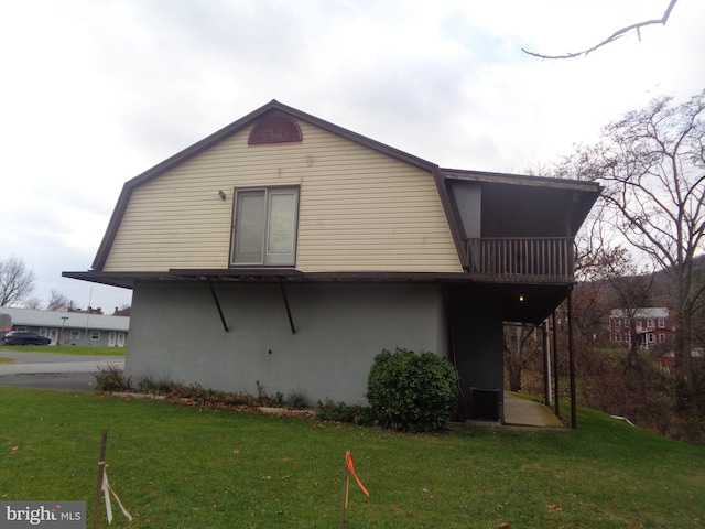 back of house with a balcony and a yard