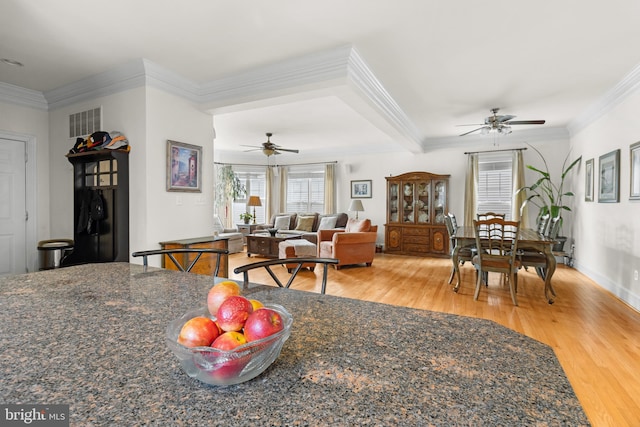 dining space with hardwood / wood-style flooring, ornamental molding, and ceiling fan