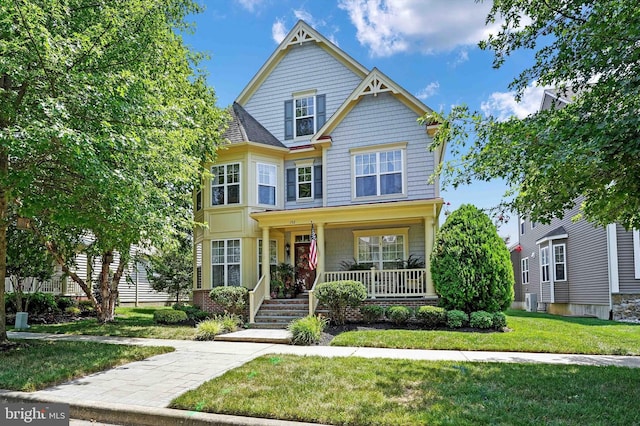 view of front of home with covered porch and a front yard