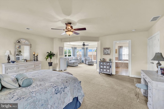 bedroom with light carpet, ceiling fan, ensuite bath, and multiple windows