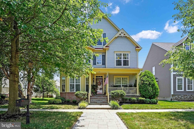 craftsman-style home with a front lawn and a porch