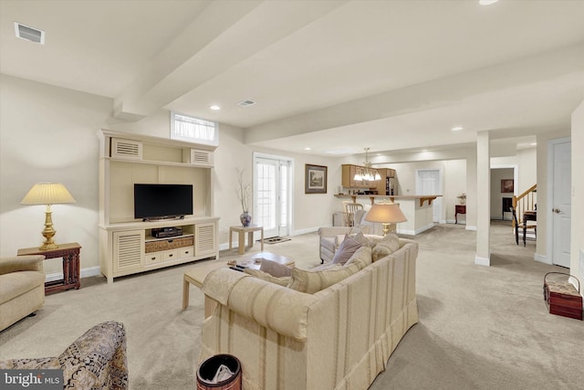 living room featuring light carpet and a notable chandelier