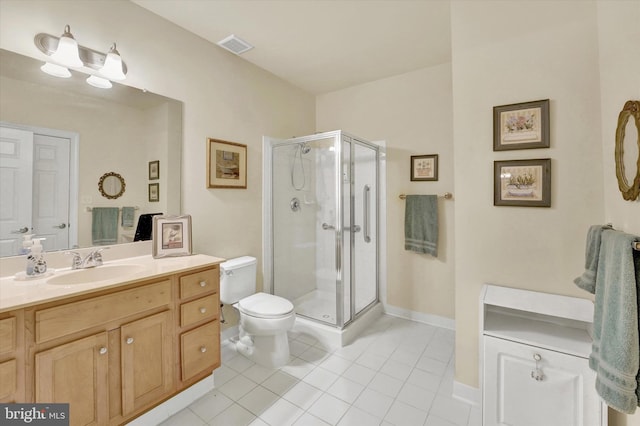 bathroom with vanity, toilet, tile patterned floors, and a shower with door