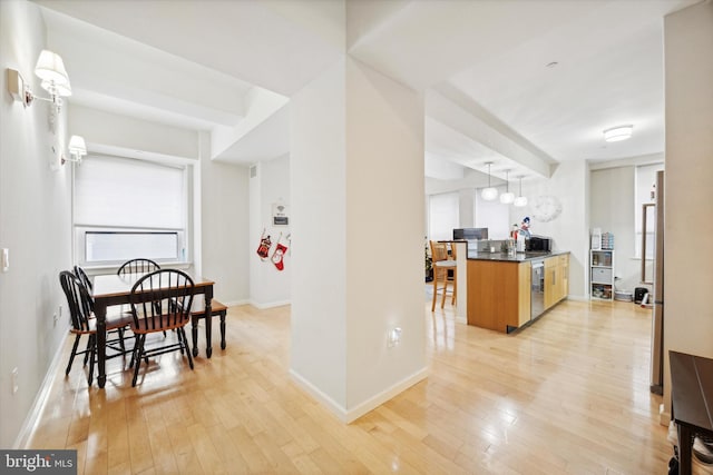 kitchen with decorative light fixtures and light wood-type flooring