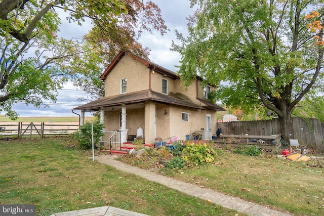 back of property featuring a lawn