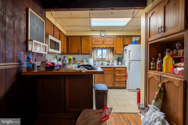 kitchen with light tile patterned flooring, white appliances, and sink