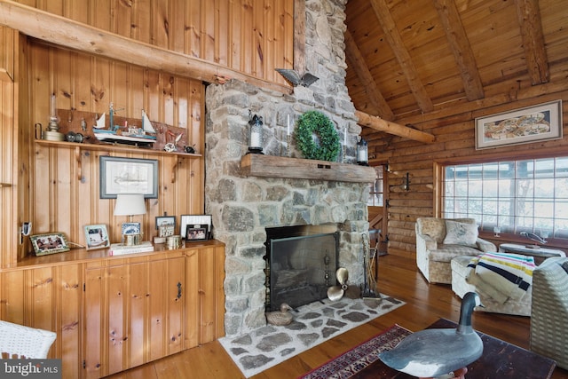 living room with hardwood / wood-style floors, high vaulted ceiling, a stone fireplace, beamed ceiling, and wood ceiling