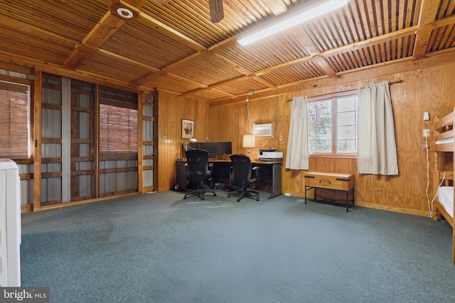 carpeted home office featuring ceiling fan and wooden walls