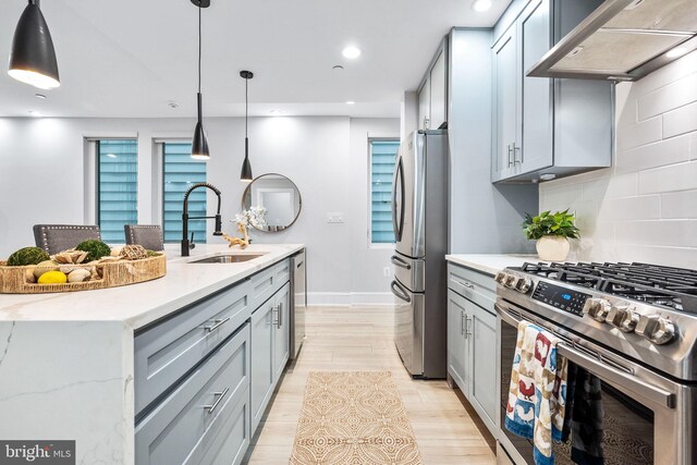 kitchen featuring light stone countertops, backsplash, custom exhaust hood, stainless steel appliances, and hanging light fixtures