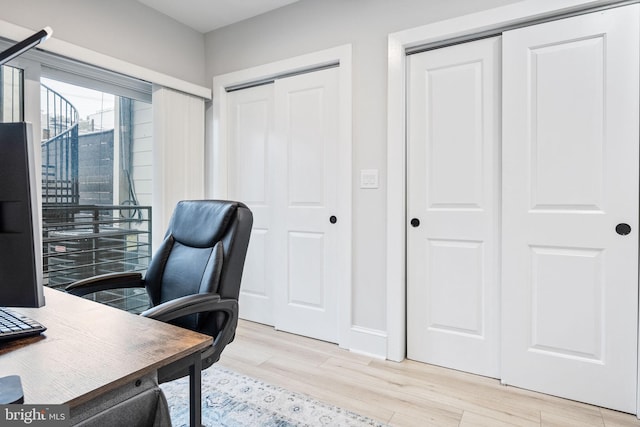 home office with light hardwood / wood-style floors