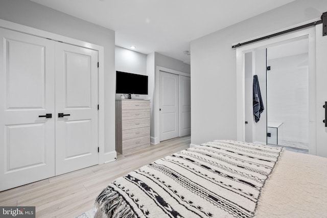 bedroom featuring light hardwood / wood-style floors and a barn door