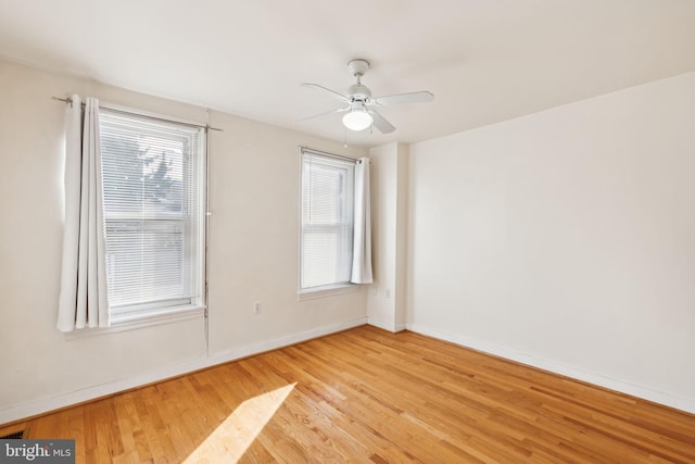 empty room featuring ceiling fan, plenty of natural light, and light wood-type flooring