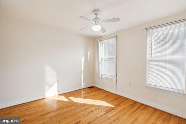 spare room with wood-type flooring, ceiling fan, and a healthy amount of sunlight