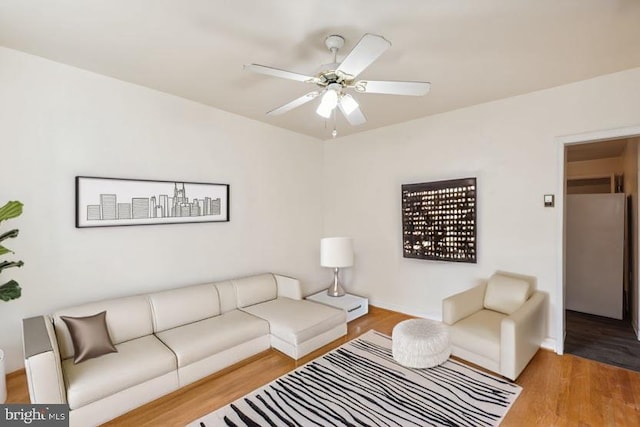 living room featuring wood-type flooring and ceiling fan