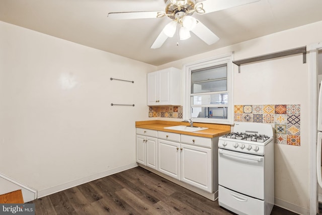 kitchen with white range with gas stovetop, white cabinetry, ceiling fan, and dark wood-type flooring