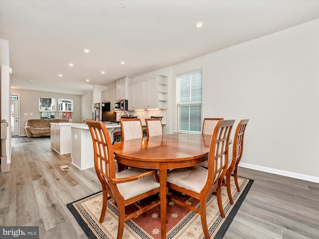 dining space with light hardwood / wood-style floors and a wealth of natural light