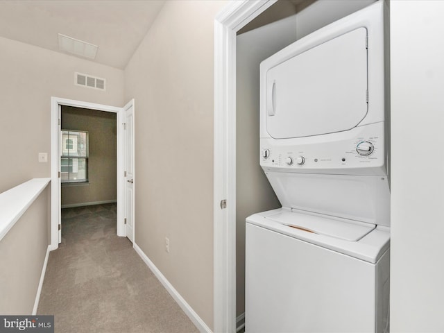 laundry area with light colored carpet and stacked washing maching and dryer