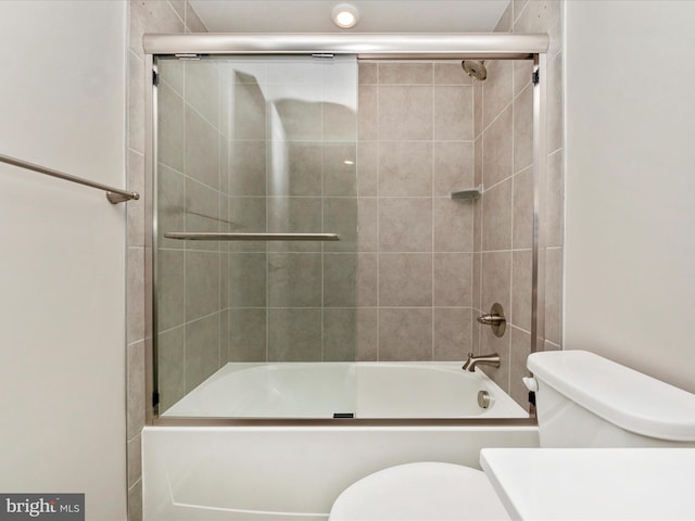 bathroom featuring shower / bath combination with glass door and toilet