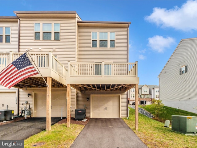 multi unit property with cooling unit, a front yard, and a garage